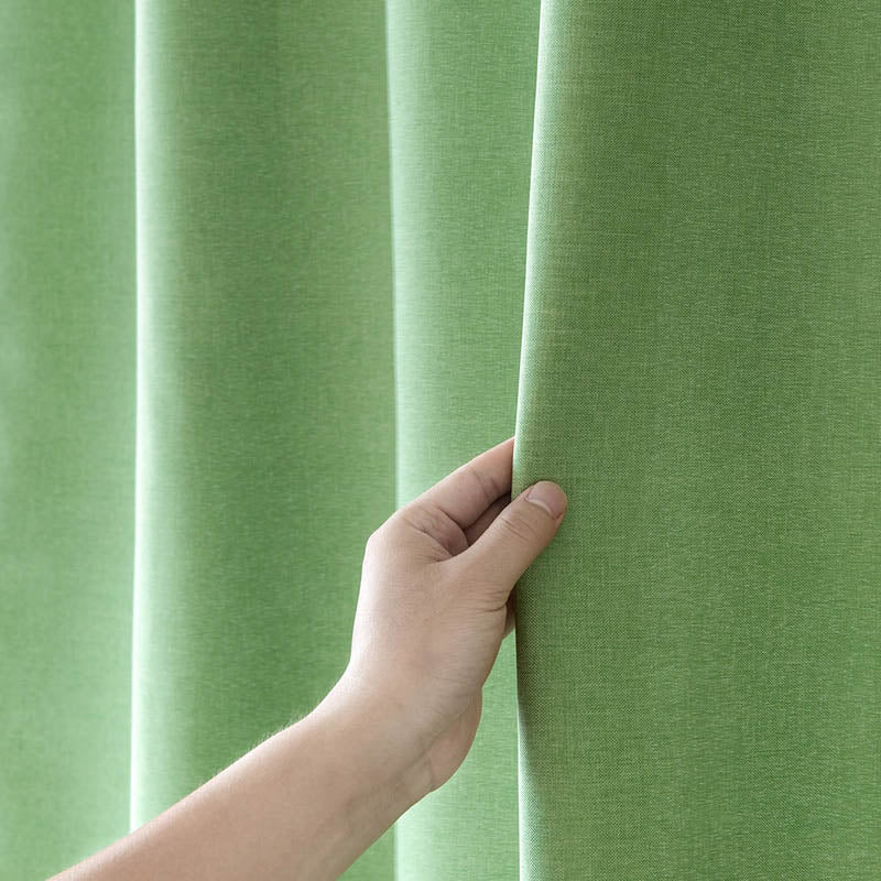 Full drop of the plain olive green curtain on its rail