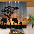 Black silhouettes of an acacia and three elephants against an orange sunset sky