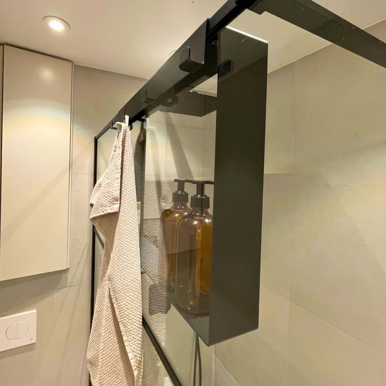Black over-screen caddy styled in a modern walk in shower enclosure