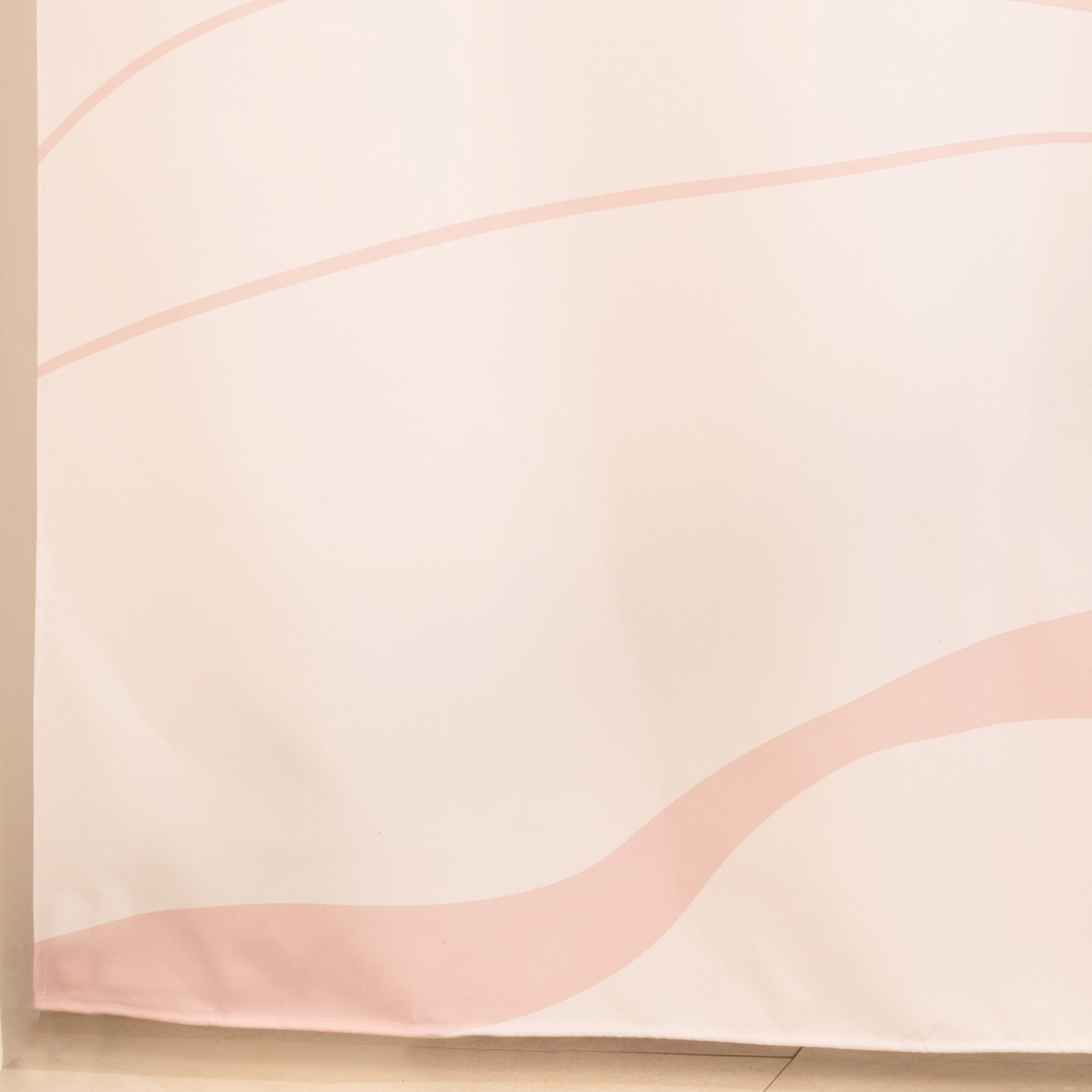 Full length pale pink curtain hanging beside a glass shower screen