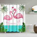 Two facing pink flamingos framed by green tropical leaves on a white ground