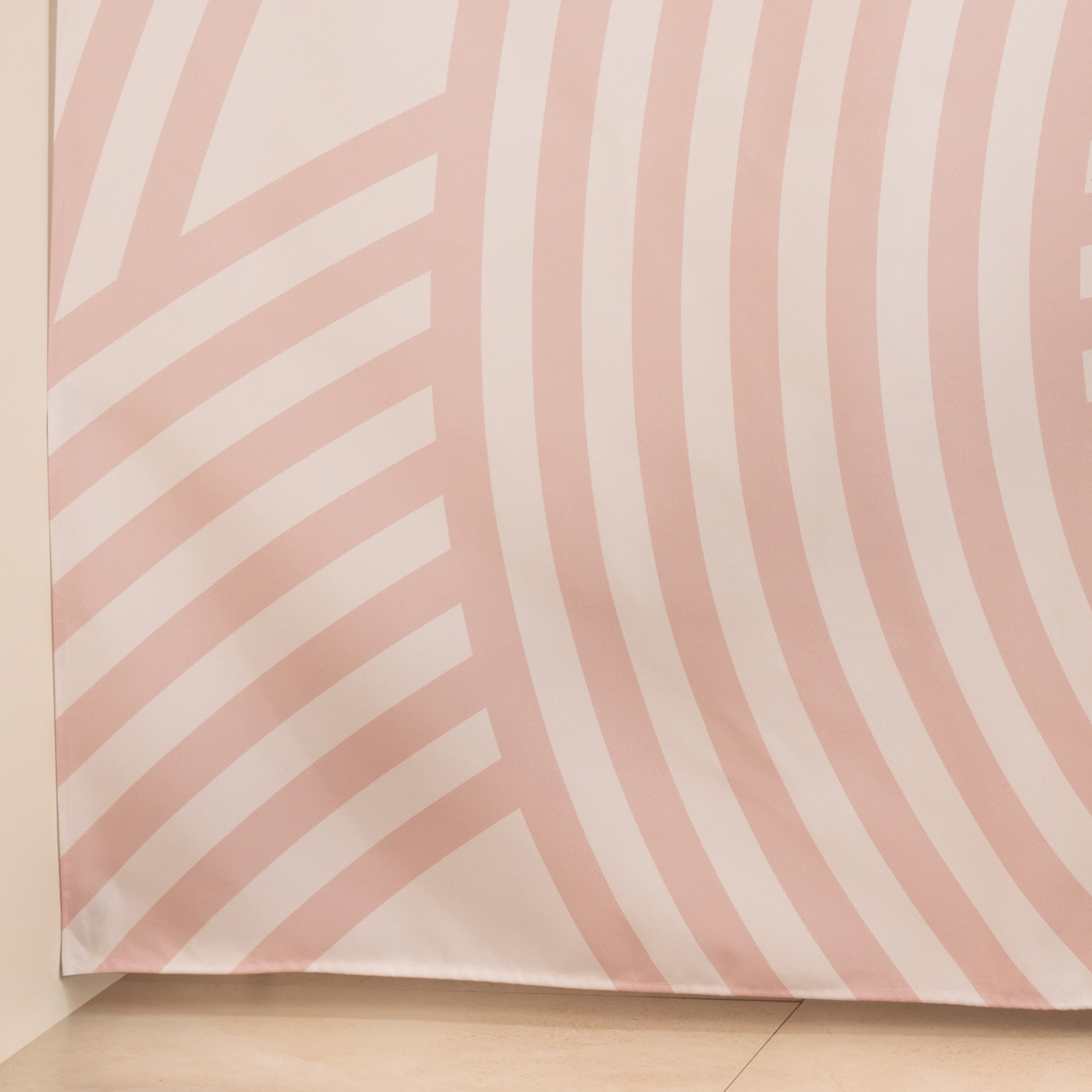 Full length pink arc curtain hanging beside a glass shower screen