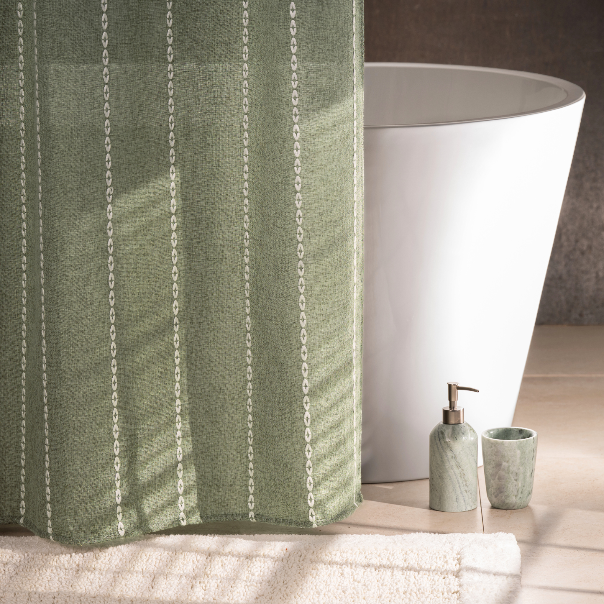 Sage green curtain styled in a bright bathroom with natural light