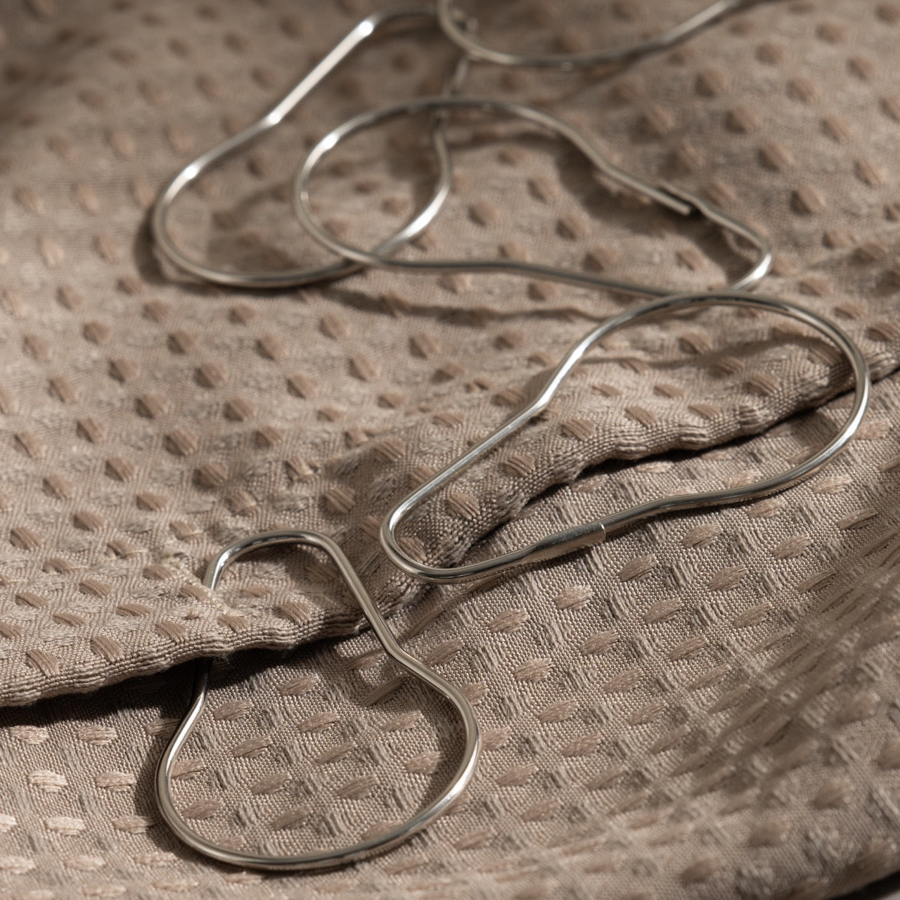 Close view of the satin silver finish on a pear shaped rail ring