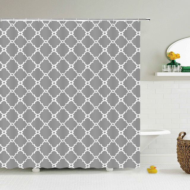 White quatrefoil trellis repeating across a mid grey curtain panel