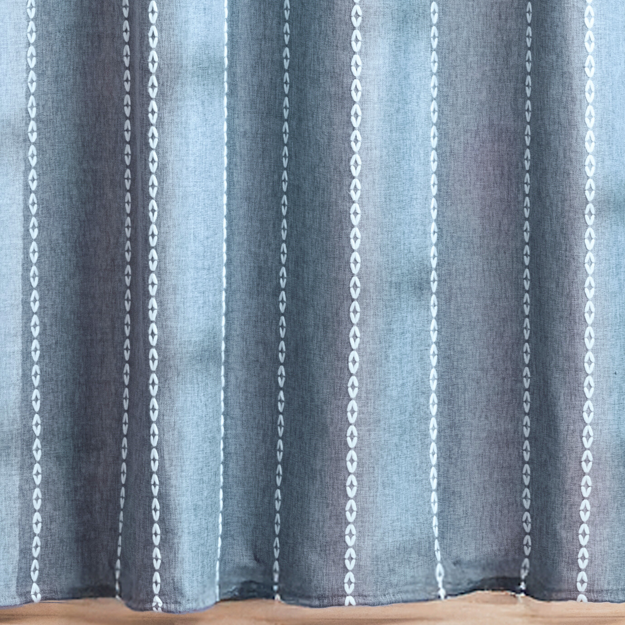 Full length blue grey curtain hanging beside a white shower tray