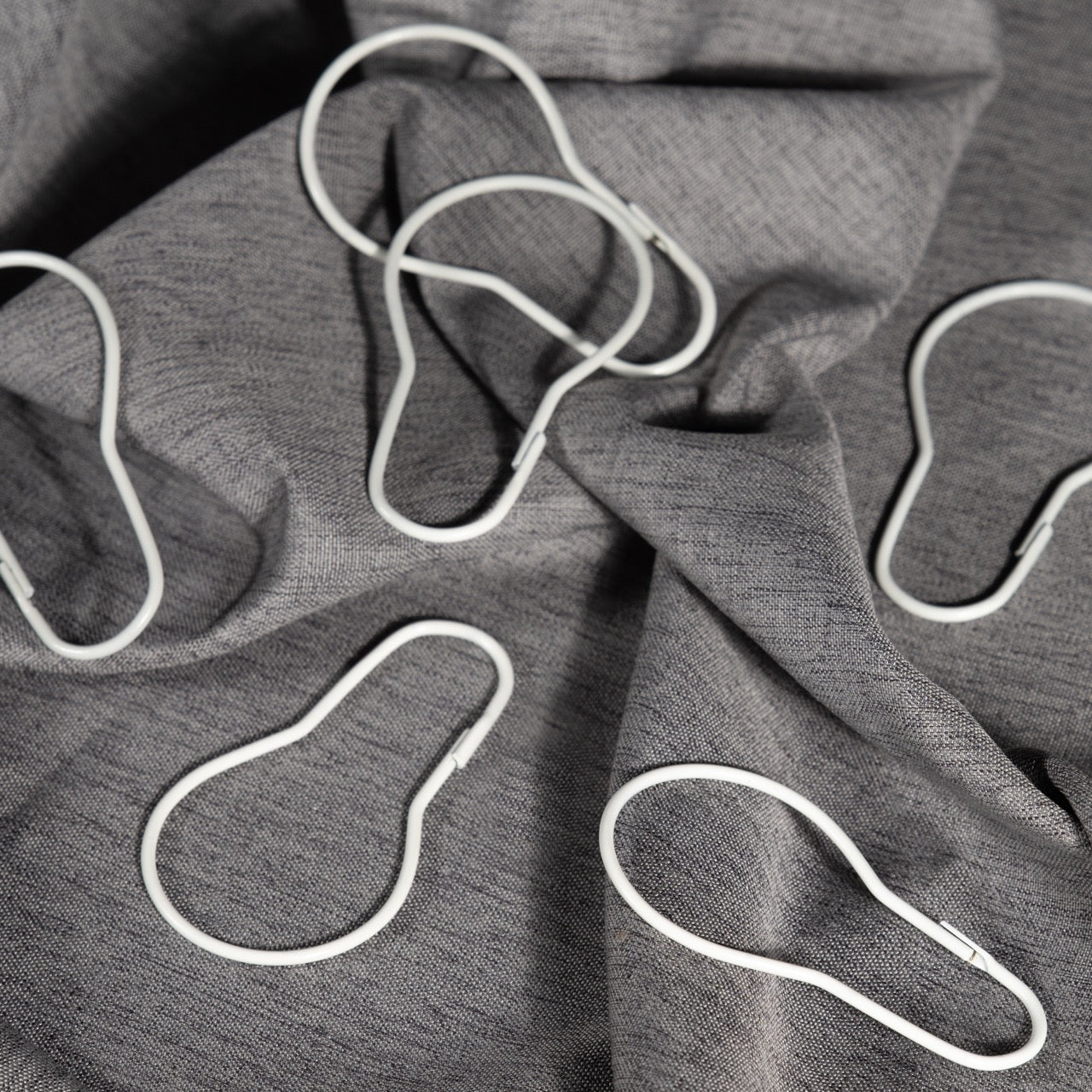 Close view of the clip closure on a plain white curtain ring