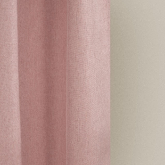 Full length solid pink curtain hanging beside a glass shower screen