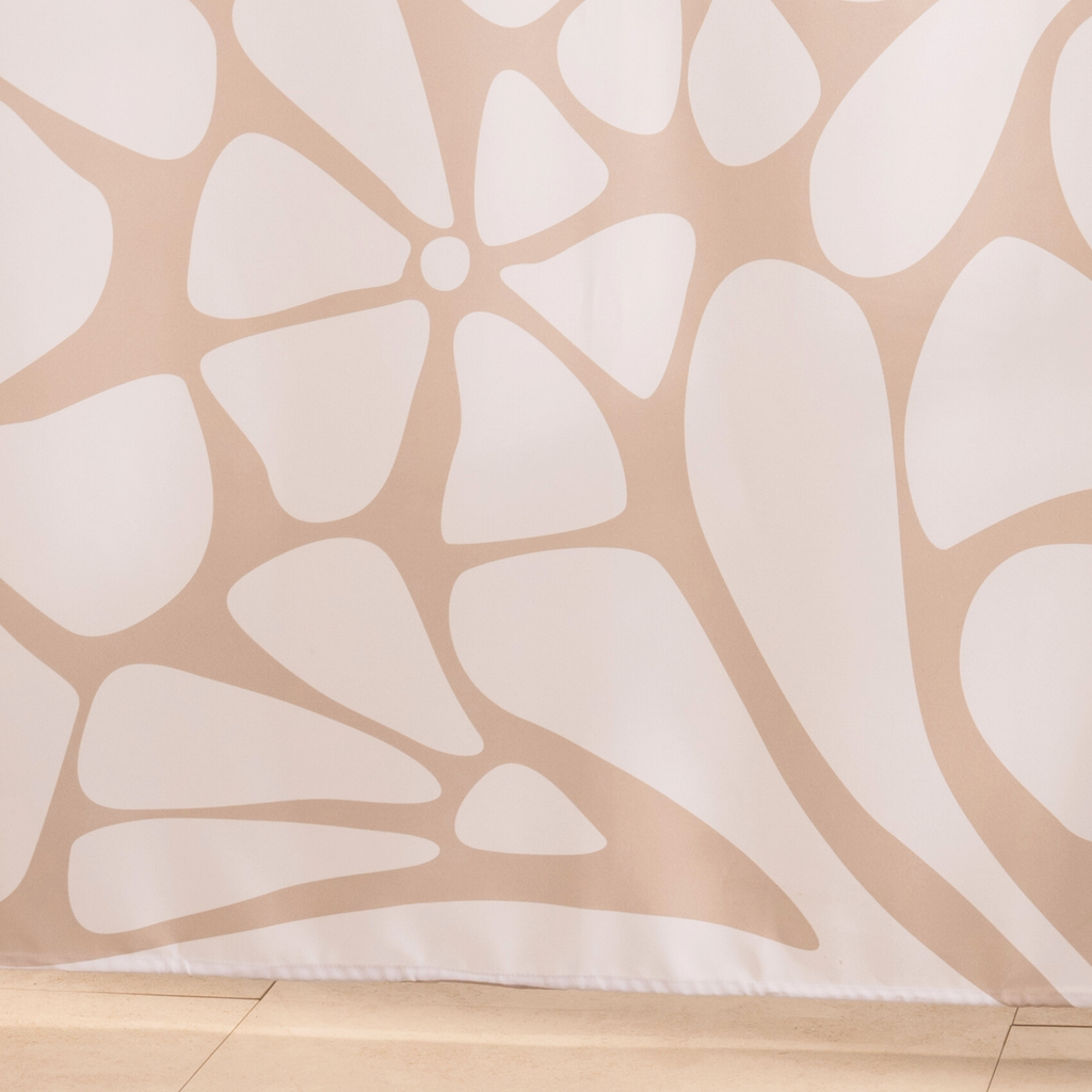 Full length taupe floral curtain hanging beside a glass screen
