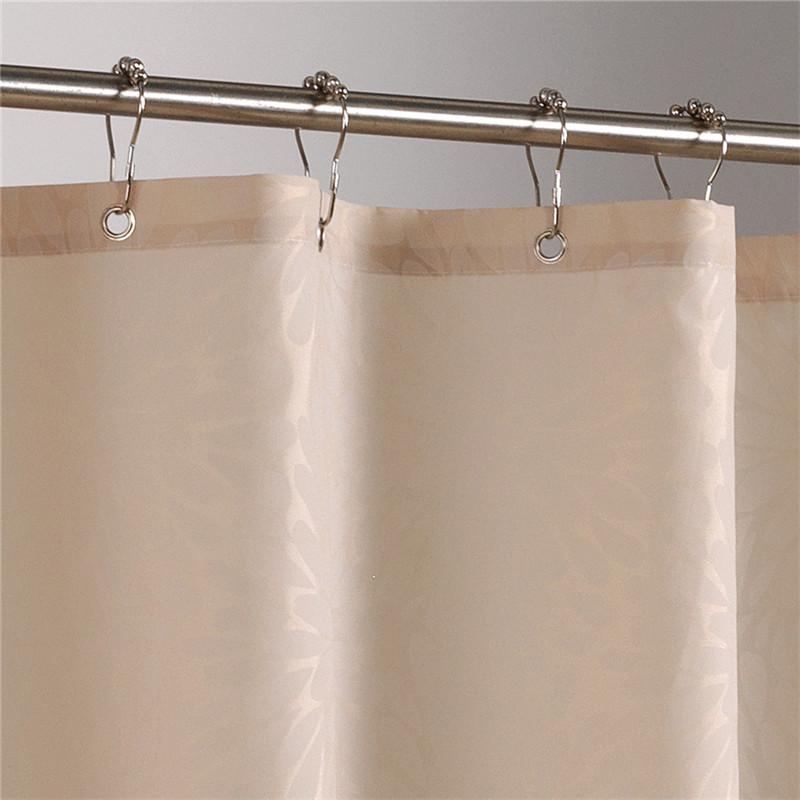 Taupe curtain hanging in front of a white bathtub in daylight