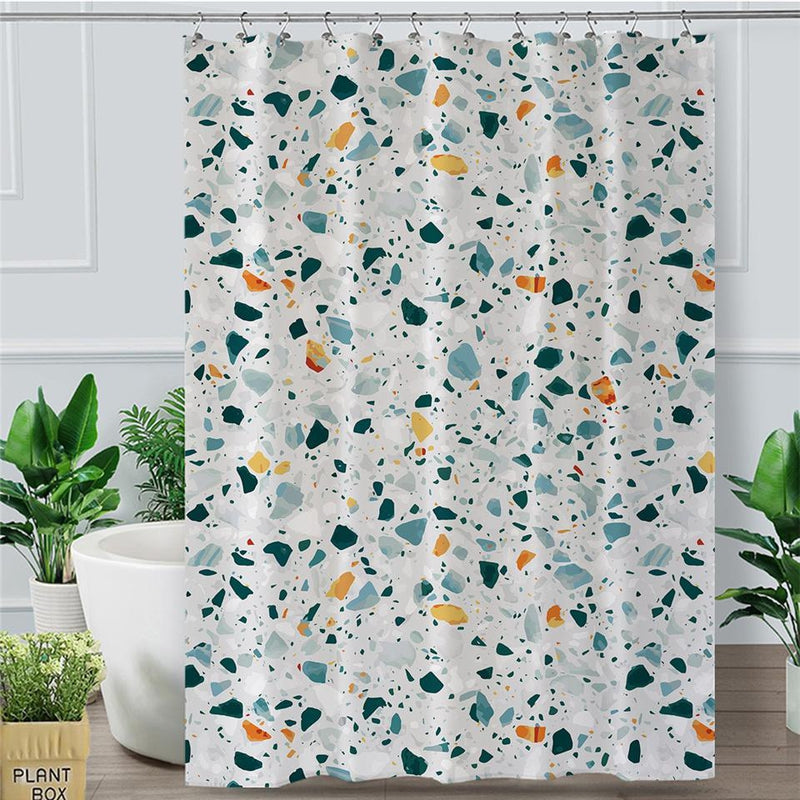 Green, blue, mustard and black terrazzo chips scattered on off-white