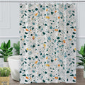 Green, blue, mustard and black terrazzo chips scattered on off-white