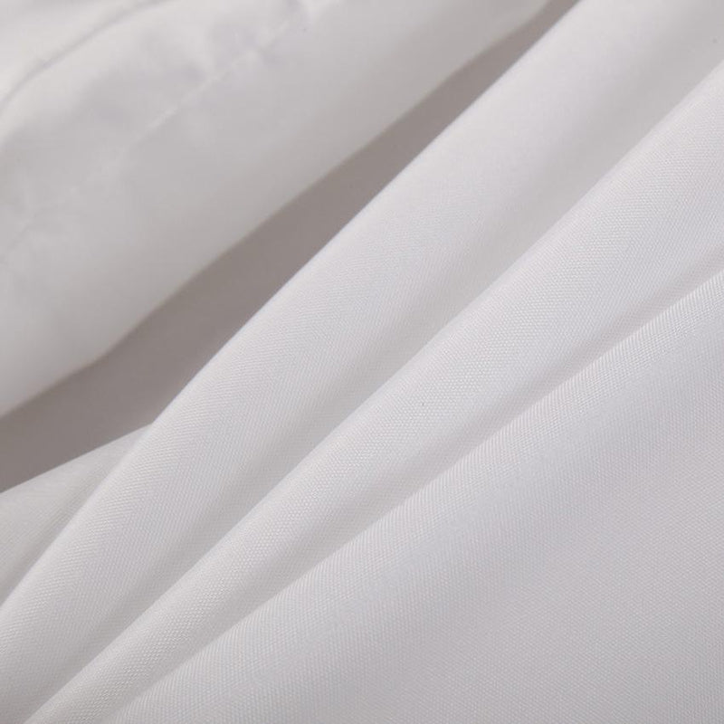 White curtain styled beside a bathtub in a light airy bathroom