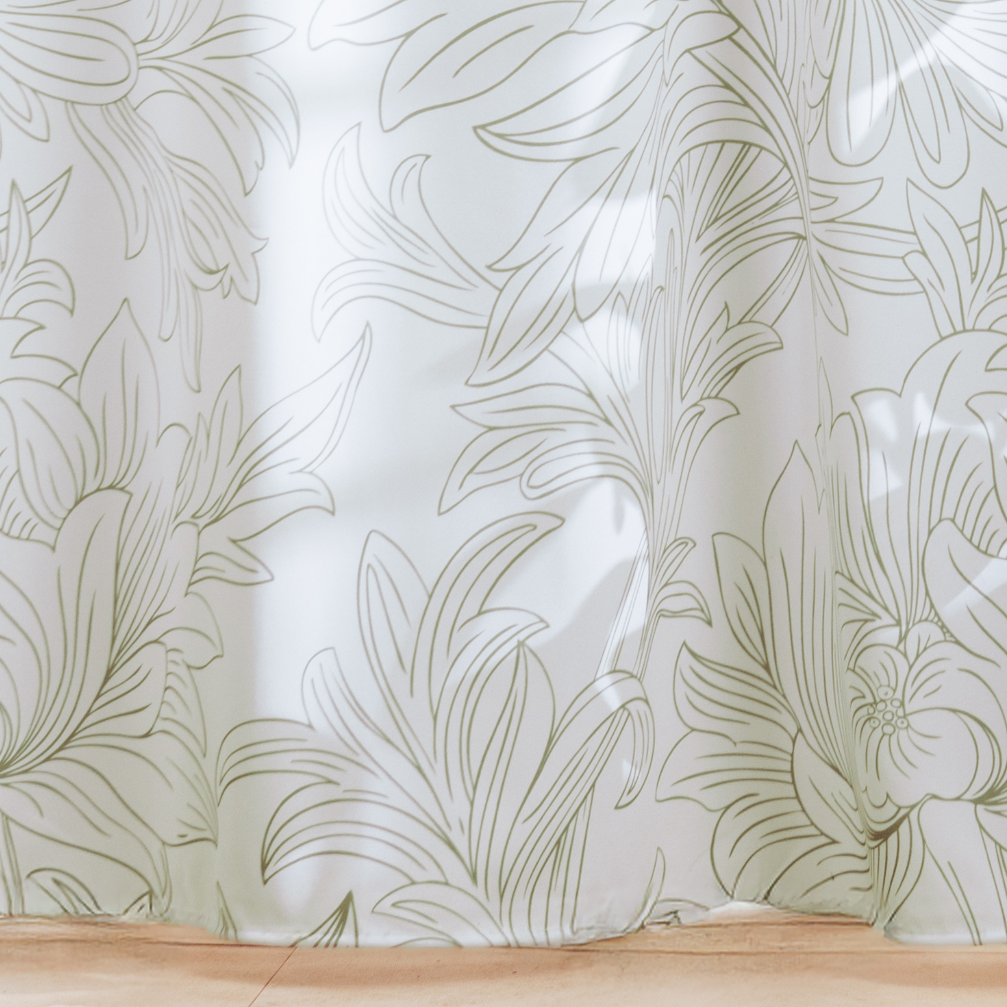 Full length white on white curtain hanging beside a glass screen