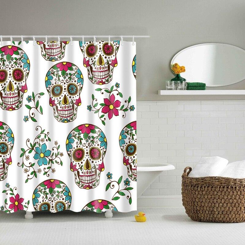 Sugar skulls decorated in pink blue and green linked by flowering green stems