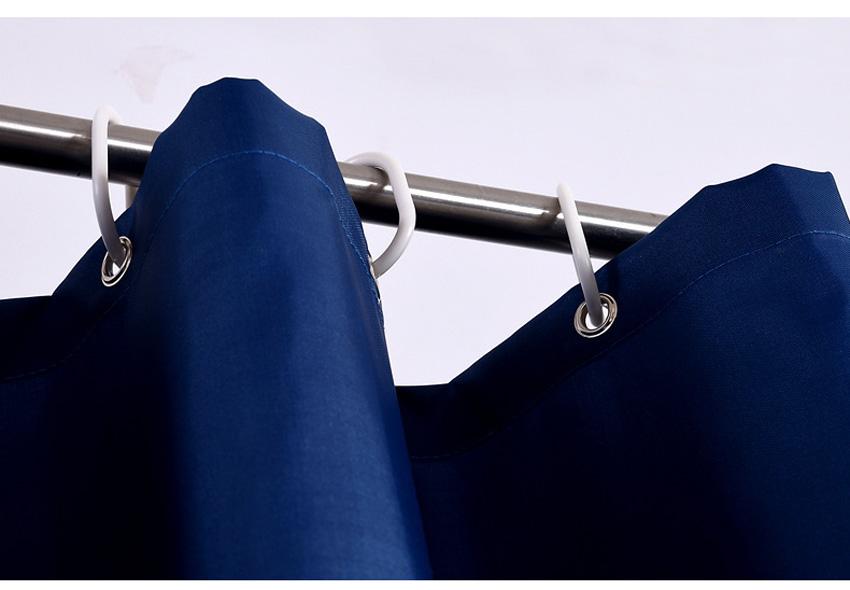 Full length navy woven curtain hanging straight beside a white bath