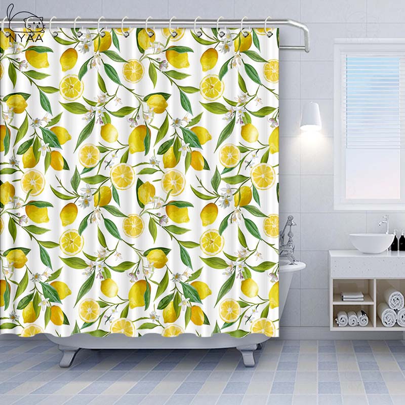Whole and halved yellow lemons with green leaves scattered on white